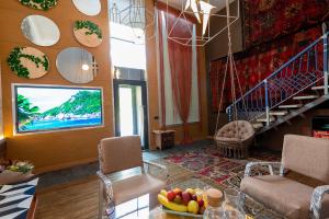 ein Wohnzimmer mit einem TV und einer Treppe in der Unterkunft Inn OZZ in Qaraghandy