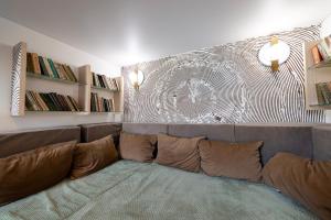 Inn OZZ في كاراغاندي: أريكة في غرفة معيشة مع رسم على الحائط