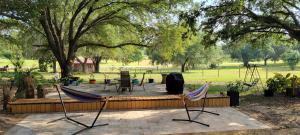 2 chaises assises sur une terrasse dans un parc dans l'établissement Camper on 5 acres, à Clermont