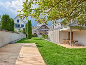 a garden with a wooden walkway in a yard at Boutique Guesthouse Villa Pescheria B&B in Weggis