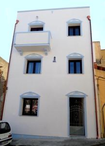 un edificio blanco con ventanas y una puerta en The Blue Lighthouse, en SantʼAntìoco