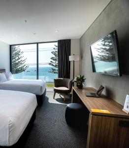 um quarto de hotel com duas camas e uma secretária em Sudima Kaikōura em Kaikoura