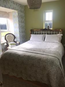 um quarto com uma cama grande e uma cadeira em Burton Hall - Pauline em Carlow