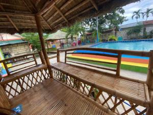 un banc en bois installé à côté d'une piscine dans l'établissement Scott's Seaview Resort, à Idanao