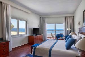 a hotel room with a bed and a view of the ocean at Solymar Reef Marsa in Coraya Bay