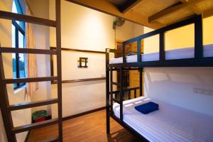a room with two bunk beds and a window at Travel Hub Highstreet in Kuala Lumpur