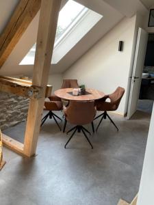 een eetkamer met een tafel en stoelen op een zolder bij Zimmermanns 2 in Monschau