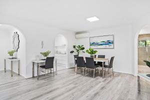 a dining room with white walls and a table and chairs at Coco Bella Retreat in Central Surfers - sleeps 6-8 in Gold Coast