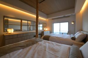 a bedroom with two beds and a large window at 旅乃家 宇佐美温泉 海ホテル 本館ーアネックス館 in Ito