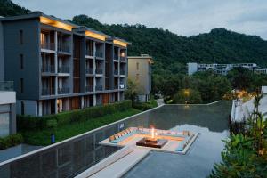 an apartment building with a fire in the middle of a pool at The Peri Hotel Khao Yai in Phayayen