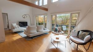 a large living room with white furniture and windows at Annupuri Chalets - Niseko in Niseko