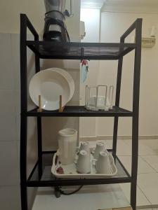 a shelf with dishes and other items on it at Yuslina Homestay in Bandar Puncak Alam