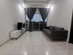 a living room with a couch and a television at Yuslina Homestay in Bandar Puncak Alam