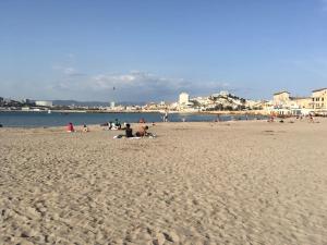 Grupa ludzi na plaży, blisko wody w obiekcie Appartement à 20 mètres de la plage avec balcon w Marsylii
