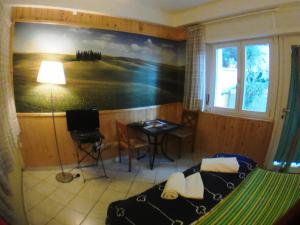 a bedroom with a bed and a desk and a painting at La Casa di Ulisse B&B in Quercianella