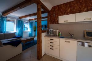 a kitchen with white cabinets and a living room at Ferienwohnung im Harz in Veckenstedt