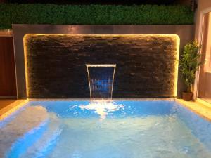 a water fountain in a pool with a brick wall at The Apex private pool villa Krabi in Krabi town