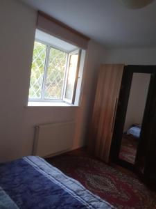 a bedroom with a bed and a mirror and a window at Apartament Simona in Braşov