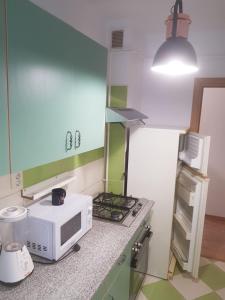 a kitchen with a white microwave and a stove at Apartament Simona in Braşov