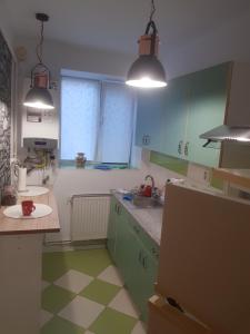 a kitchen with green and white floors and two lights at Apartament Simona in Braşov