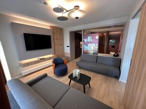 a living room with a couch and a flat screen tv at Apartment-Hotel Hamburg Mitte in Hamburg