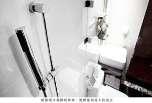 uma casa de banho com um WC e uma cabina de duche em vidro. em Royal Group Hotel Ho Yi Branch em Kaohsiung