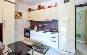 kuchnia z białymi szafkami i czarnym stołem w obiekcie Casa 121 G w mieście Pizzo