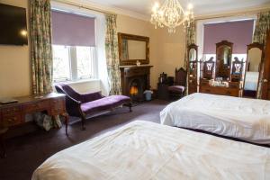 a hotel room with two beds and a fireplace at St Michaels Guest House in Elgin