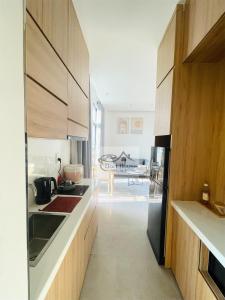 - une cuisine avec des placards en bois et un réfrigérateur noir dans l'établissement Dori House, à Gò Công