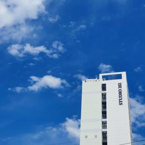 een hoog wit gebouw met een blauwe lucht op de achtergrond bij Busan Studio 202 in Busan