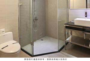 uma casa de banho com um chuveiro, um WC e um lavatório. em Royal Group Hotel Chang Chien Branch em Kaohsiung