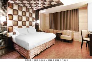a hotel room with a bed and a desk and chair at Royal Group Hotel Chang Chien Branch in Kaohsiung