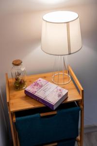 a table with a lamp and a book on it at Apart Invest Żeromskiego 15/8 in Szklarska Poręba