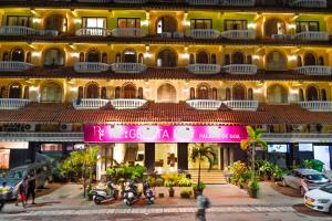 un gran edificio con una señal rosa delante de él en Regenta Inn Palacio De Goa, Panjim en Panaji