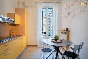 Easylife - Classic and Comfy Porta Romana Flat في ميلانو: مطبخ صغير مع طاولة وكراسي ونافذة