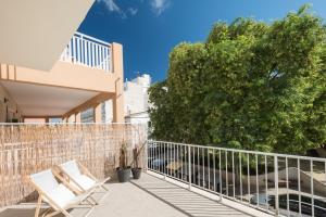 a balcony with two chairs and a tree at Forenna Hostel in El Arenal