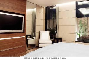 a bedroom with a bed and a flat screen tv at Royal Group Hotel Chun Shan Branch in Kaohsiung