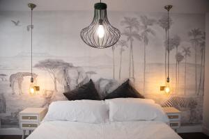- une chambre avec un lit et un mur orné de palmiers dans l'établissement Apartamentos Boutique Cervantes, à Plasence