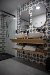 a bathroom with two sinks and a mirror at Apartamentos Boutique Cervantes in Plasencia