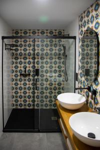 a bathroom with a shower with a sink and a mirror at Apartamentos Boutique Cervantes in Plasencia