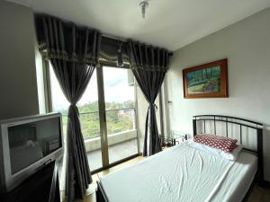 a bedroom with a bed and a large window at One Tagaytay Place Private Residences in Tagaytay