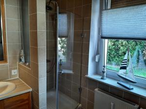 ein Badezimmer mit einem Waschbecken und einer Dusche mit einem Spielzeugboot im Fenster in der Unterkunft Ferienwohnung am Park in Pegau