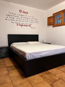 łóżko w pokoju z napisem na ścianie w obiekcie Casa Spaziosa: Adelfia w mieście Adelfia