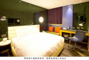 a bedroom with a bed and a desk and a chair at Royal Group Hotel Bo Ai Branch in Kaohsiung
