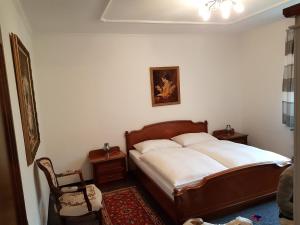a bedroom with a large bed and a chair at Landhaus Maria in Velden am Wörthersee