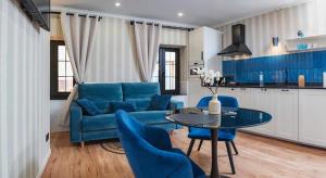 a living room with a blue couch and a table at "Breeze" Aparthotel by Parrot`s House in Lloret de Mar