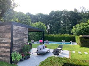 einen Garten mit einem Pavillon und einem Pool in der Unterkunft Vakantiehuis sINNE in Oostmalle
