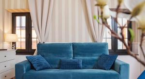 a blue couch with blue pillows in a living room at "Breeze" Aparthotel by Parrot`s House in Lloret de Mar