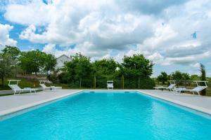 une grande piscine avec des chaises blanches dans l'établissement Luxury Villa Maria with large pool, à Suhovare