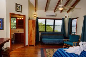 a bedroom with a bed and a couch and a window at Sunset Lagoon Cabanas in Maya Beach